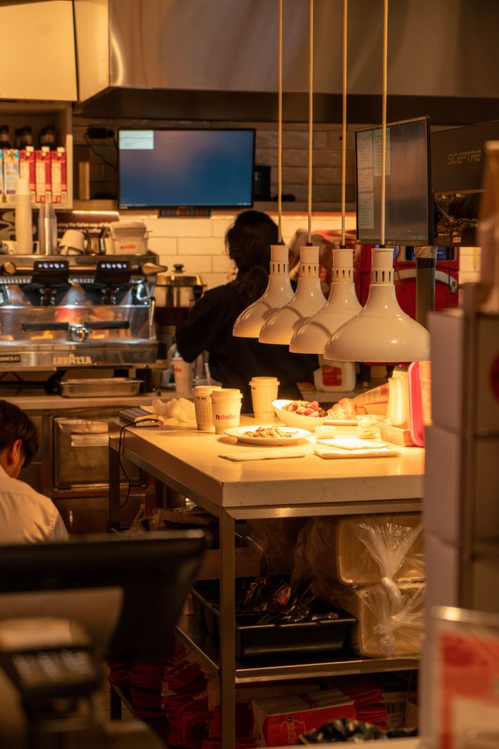 Warm lighting in a busy cafe kitchen with chefs at work, Illinois, USA.